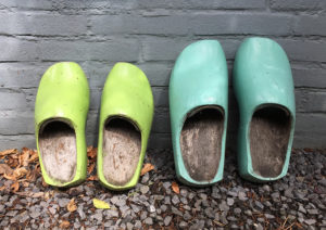 groene klompen tegen blauwe muur